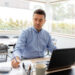 remote job, business and people concept - middle-aged man with calculator, papers and laptop computer working at home office